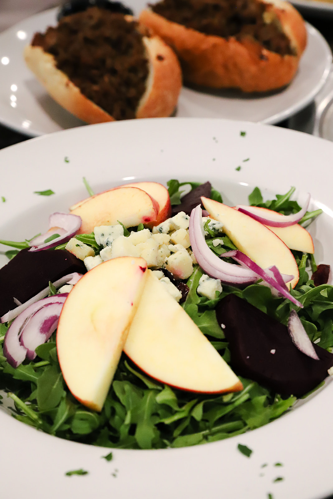 Salad with apples and cheese and cheesesteak